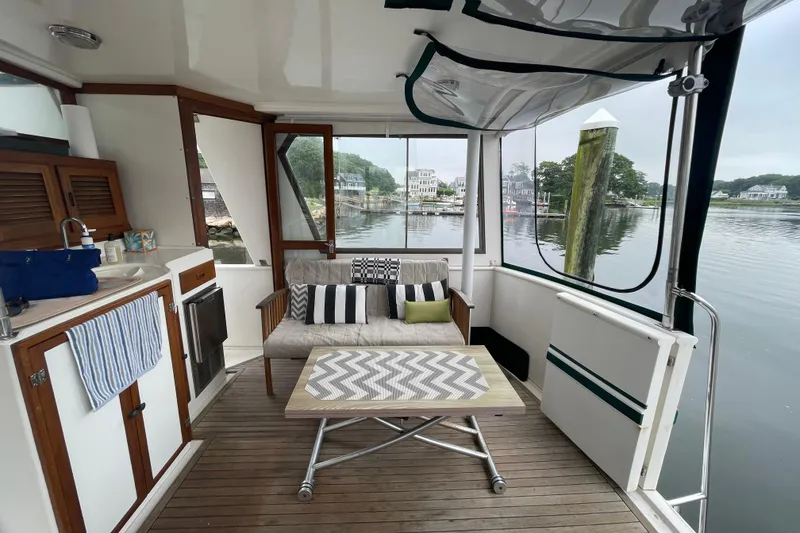 Slide: The Image of 1987 Heritage East 40 Sundeck interior with cozy seating and scenic waterfront view. - 5