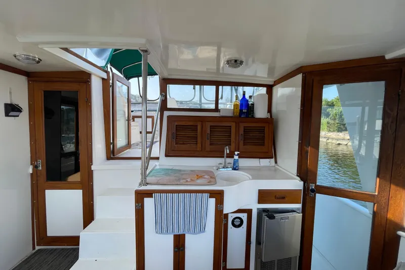 Slide: The Image of 1987 Heritage East 40 Sundeck interior with wooden cabinetry and compact kitchenette. - 6