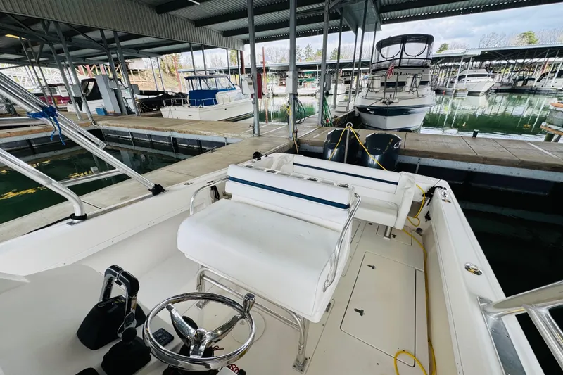 Slide: The Image of 2008 Intrepid 327 boat docked in a marina, featuring a steering wheel and seating area. - 10