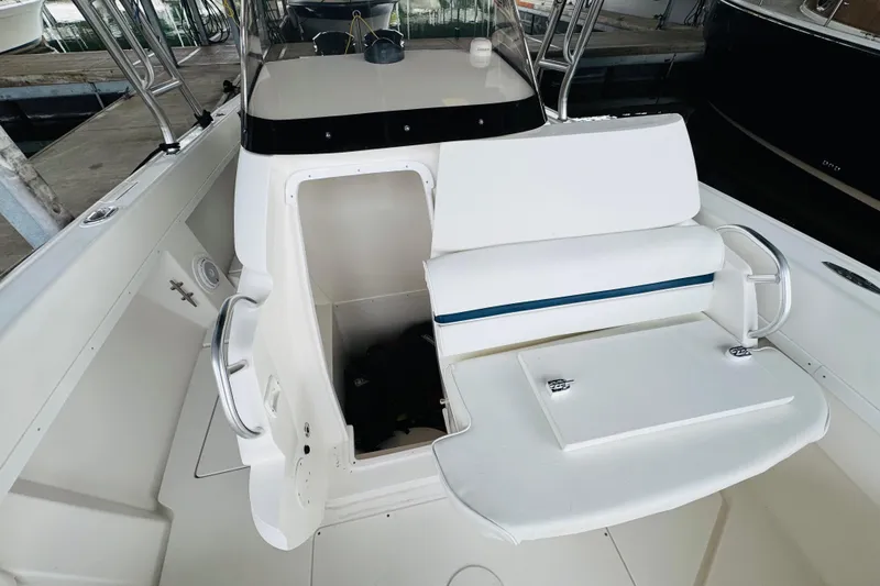 Slide: The Image of 2008 Intrepid 327 boat interior with white seating and storage compartment. - 18