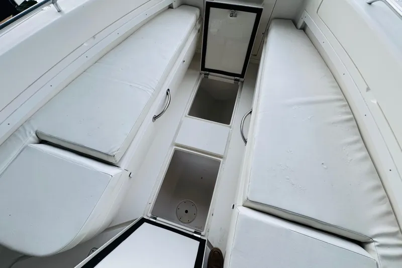 Slide: The Image of 2008 Intrepid 327 boat interior with open storage compartments and cushioned seating. - 20