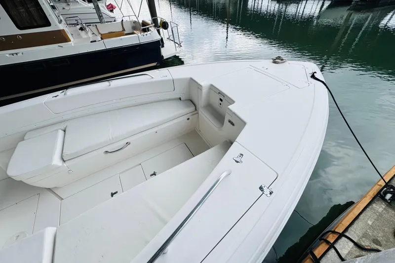 Slide: The Image of 2008 Intrepid 327 boat docked, featuring sleek white design and spacious seating area. - 5