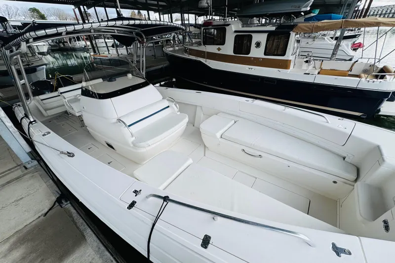 Slide: The Image of 2008 Intrepid 327 boat docked, featuring spacious seating and sleek design. - 6