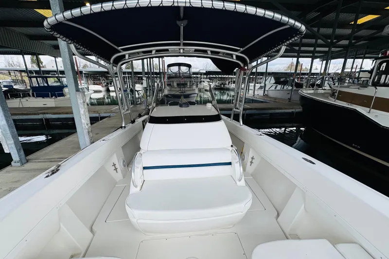 Slide: The Image of 2008 Intrepid 327 boat docked in marina, featuring spacious seating and canopy. - 8