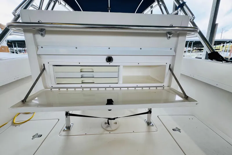 Slide: The Image of 2008 Intrepid 327 boat interior with storage compartments and foldable table. - 19