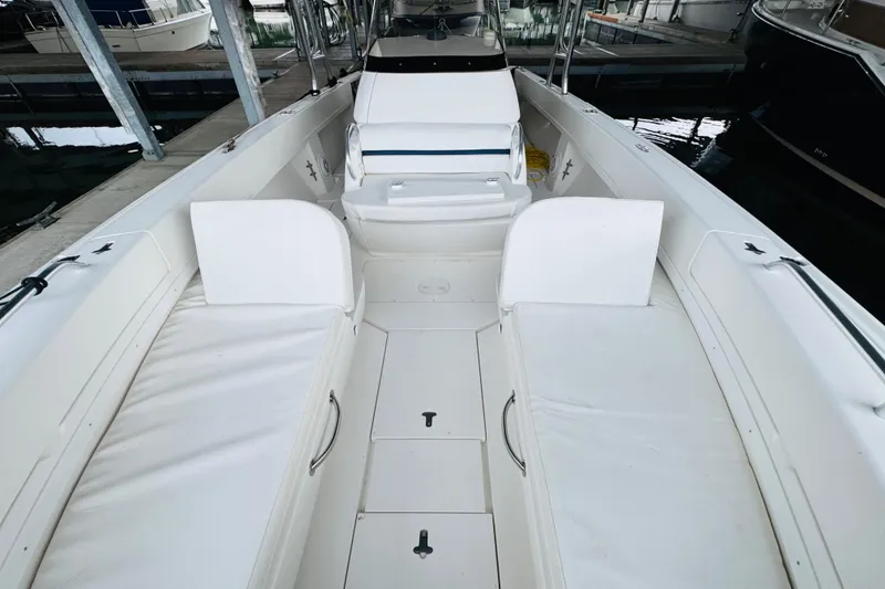 Slide: The Image of 2008 Intrepid 327 boat interior with white seating and storage compartments. - 22