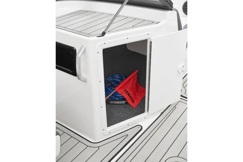 Slide: The Image of Open storage compartment on 2026 Yamaha Boats 195S, featuring a red flag and blue rope. - 19