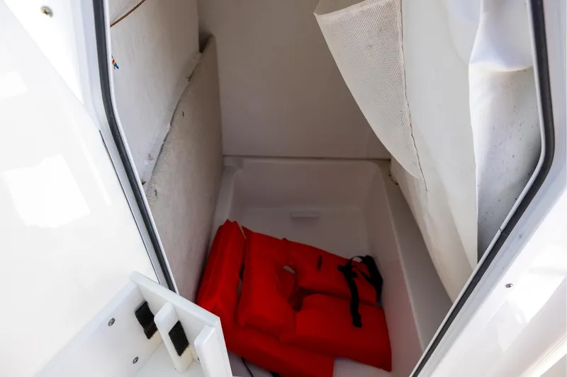 Slide: The Image of Storage compartment in 2016 Sea Hunt BX 24 BR boat with red life jacket. - 10