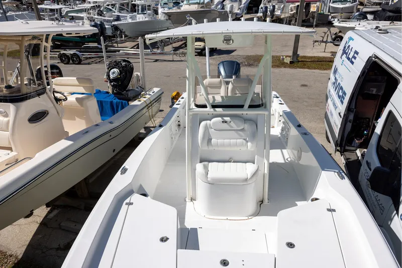 Slide: The Image of 2016 Sea Hunt BX 24 BR boat, white interior, docked among other boats and vehicles. - 12