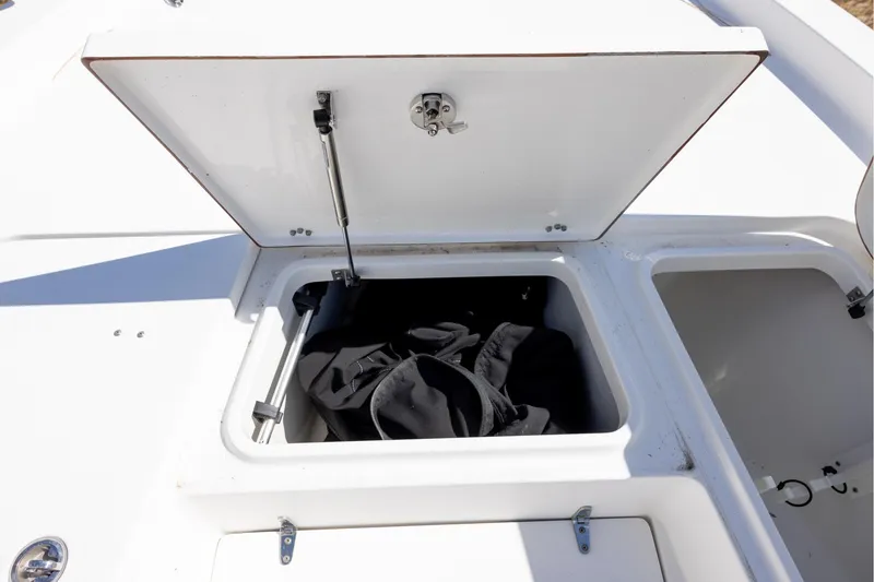 Slide: The Image of Open storage compartment on 2016 Sea Hunt BX 24 BR boat, containing black bag. - 16