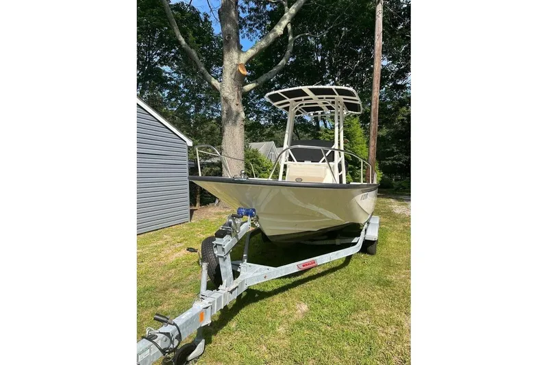The Image of 2022 Boston Whaler 190 Montauk boat on trailer, parked outdoors near trees. - 0