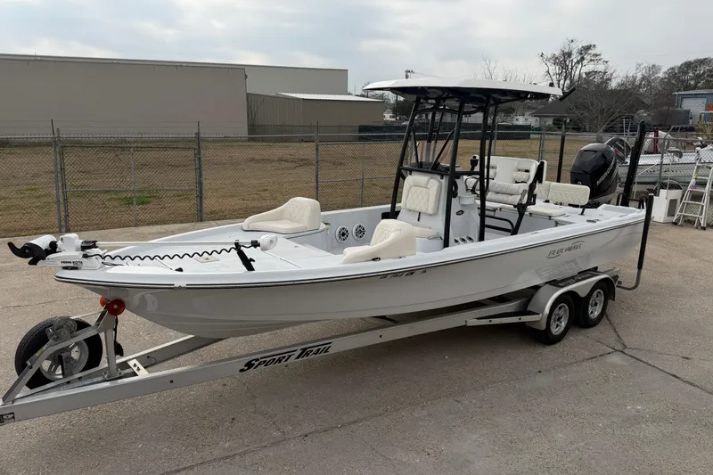 Slide: The Image of 2021 Blue Wave 2400 PureBay boat on trailer, parked outdoors, featuring sleek design and modern equipment. - 6