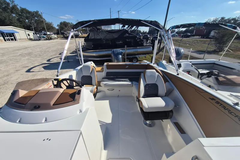 Slide: The Image of 2026 Starcraft SVX 231 OB DH boat interior with cushioned seating and cup holders. - 6