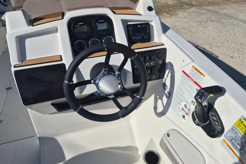 Slide: The Image of Interior view of 2026 Starcraft SVX 231 OB DH boat, featuring sleek white flooring and storage compartments. - 9