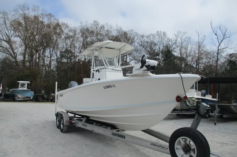 Slide: The Image of 2019 Contender 25 Tournament boat on trailer, parked outdoors with trees in background. - 3