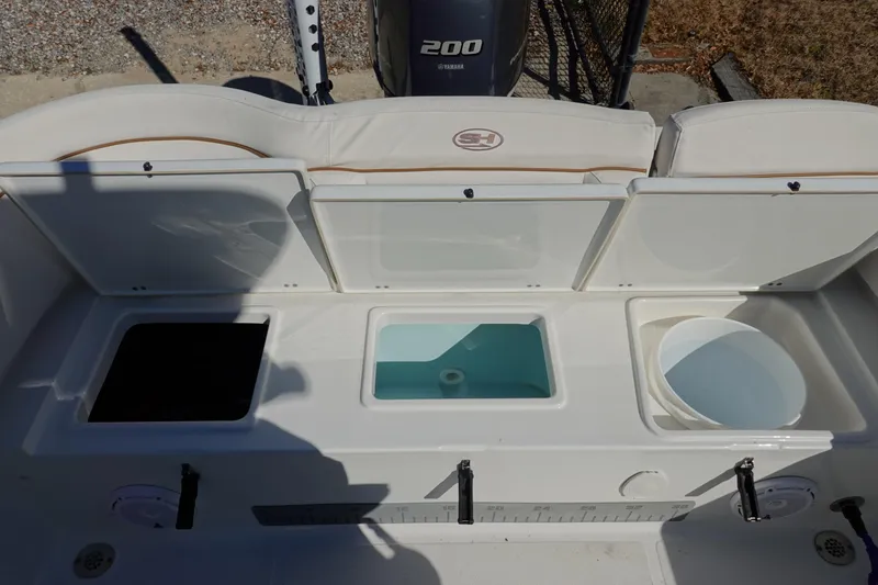 Slide: The Image of 2021 Sea Hunt Ultra 234 boat interior with storage compartments and Yamaha 200 engine. - 10