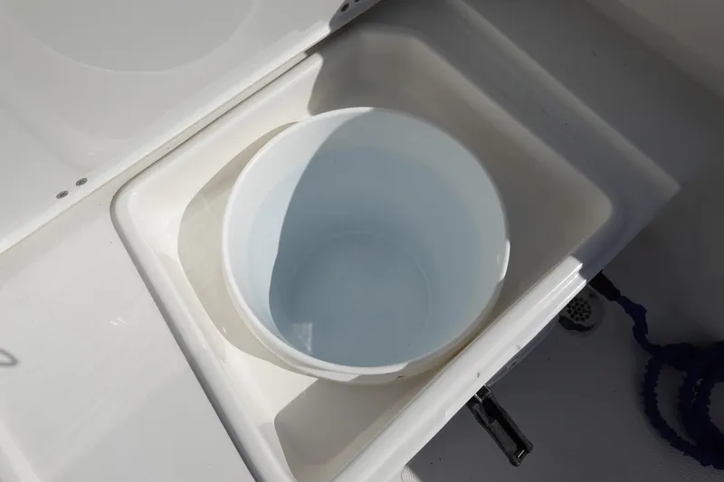 Slide: The Image of White bucket in a sink on a 2021 Sea Hunt Ultra 234 boat. - 13