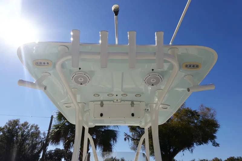 Slide: The Image of 2021 Sea Hunt Ultra 234 boat top view with rod holders and speakers under clear sky. - 14