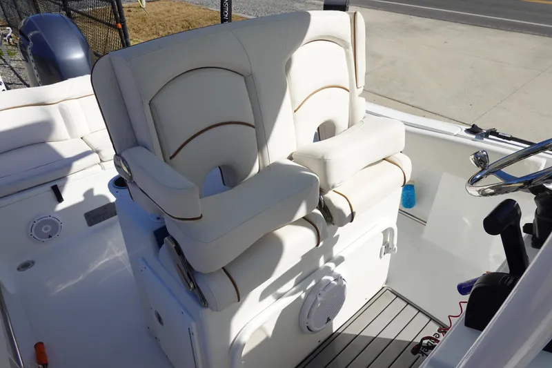 Slide: The Image of 2021 Sea Hunt Ultra 234 boat interior with white cushioned seating and steering wheel. - 19