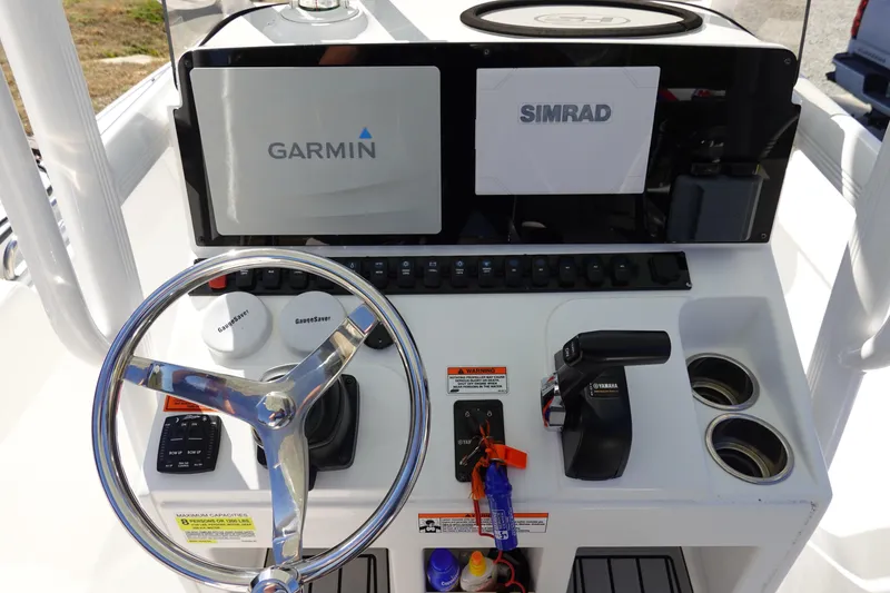 Slide: The Image of 2021 Sea Hunt Ultra 234 boat dashboard with Garmin and Simrad displays. - 21
