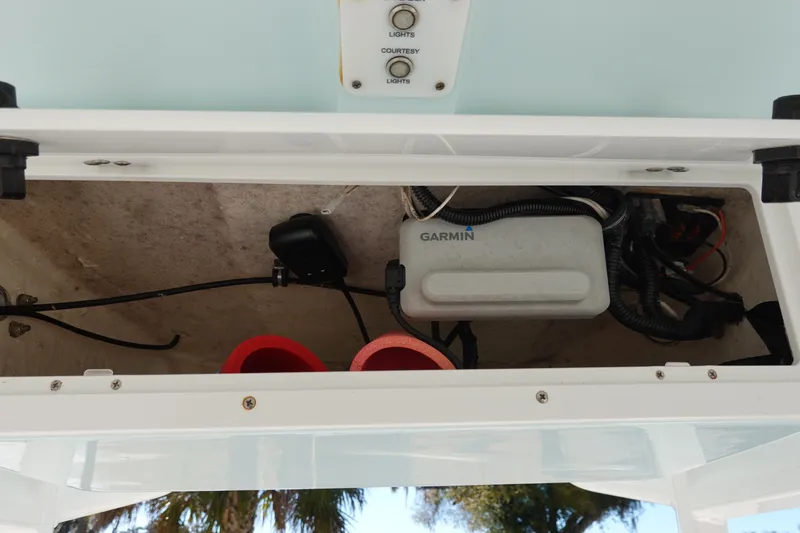 Slide: The Image of 2021 Sea Hunt Ultra 234 boat electronics compartment with Garmin device and wiring. - 23