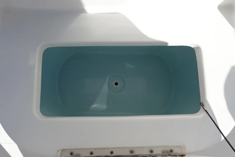 Slide: The Image of Livewell on 2021 Sea Hunt Ultra 234 boat, featuring a clean, blue interior. - 26