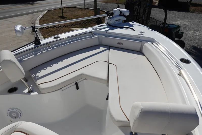 Slide: The Image of 2021 Sea Hunt Ultra 234 boat interior with white cushioned seating and fishing equipment. - 27