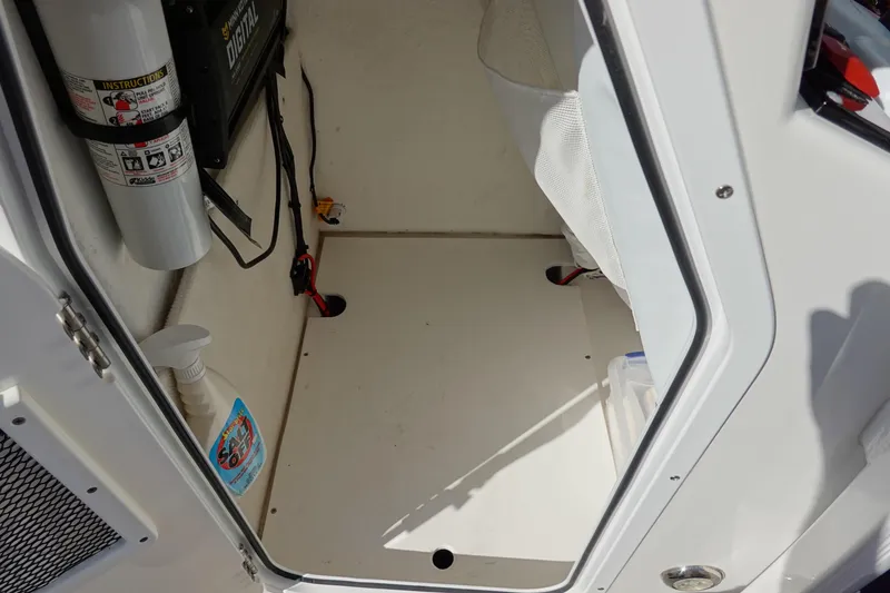 Slide: The Image of Interior of a 2021 Sea Hunt Ultra 234 boat, featuring storage space and safety equipment. - 38