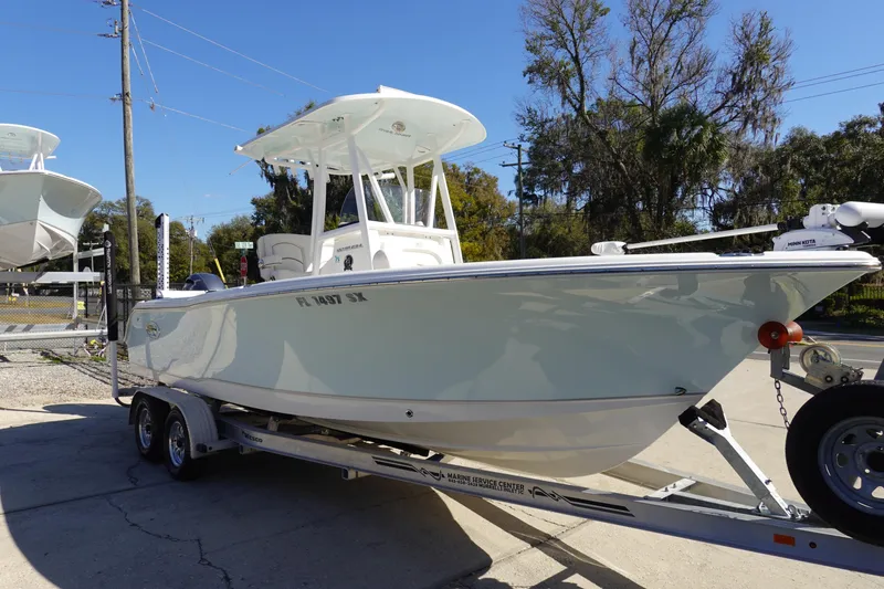 Slide: The Image of 2021 Sea Hunt Ultra 234 boat on trailer, parked outdoors under clear sky. - 4