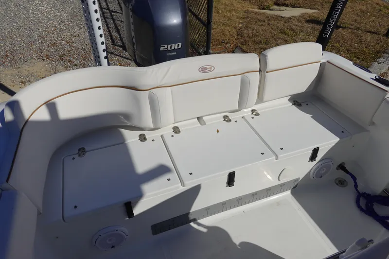Slide: The Image of 2021 Sea Hunt Ultra 234 boat interior with cushioned seating and storage compartments. - 9