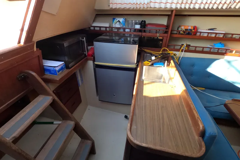 Slide: The Image of Interior of a 1980 Catalina 30 sailboat with kitchenette and seating area. - 12