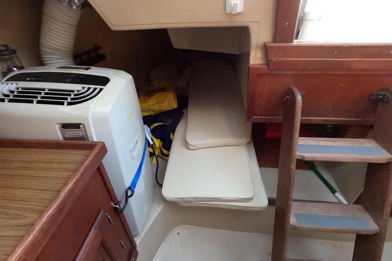 Slide: The Image of Interior of a 1980 Catalina 30 sailboat with portable air conditioner and wooden ladder. - 13