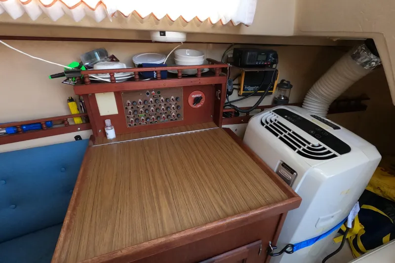 Slide: The Image of Interior of a 1980 Catalina 30 sailboat with navigation equipment and portable air conditioner. - 14