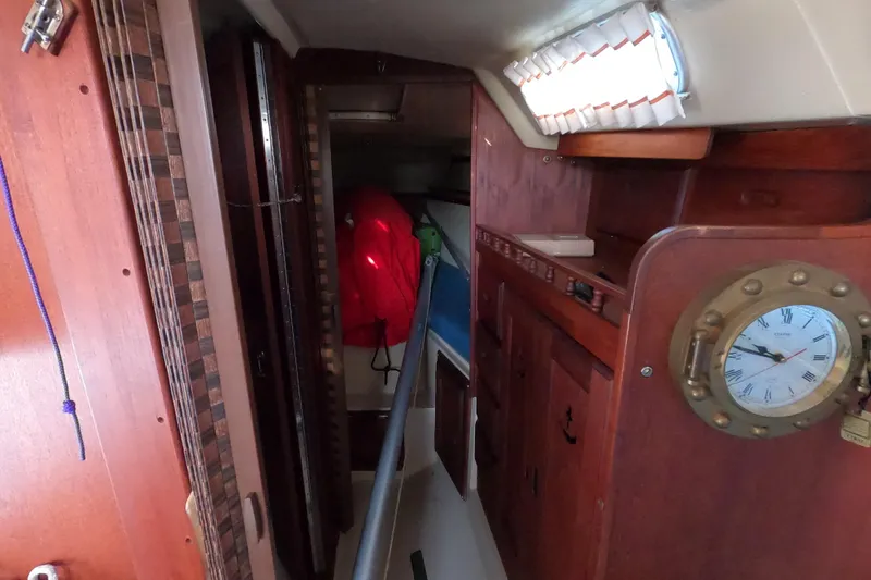 Slide: The Image of Interior of a 1980 Catalina 30 sailboat with wooden cabinetry and nautical clock. - 22
