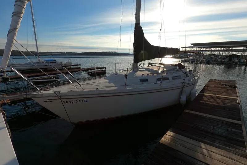Slide: The Image of 1980 Catalina 30 sailboat docked at a marina during sunset. - 25