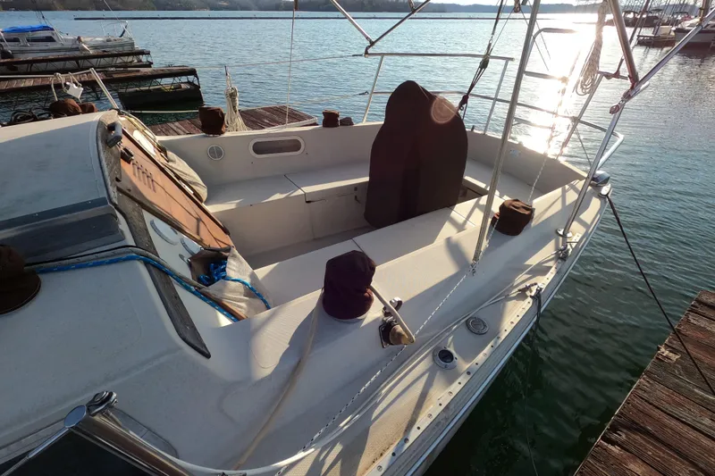 Slide: The Image of 1980 Catalina 30 sailboat docked, sunlit deck, calm waters, and marina backdrop. - 4