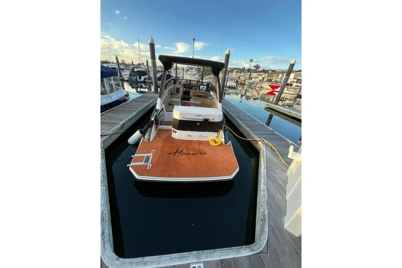 Slide: The Image of 2026 Hanover 305 boat docked at marina, featuring sleek design and wooden deck. - 3