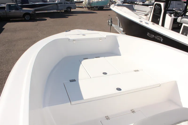 Slide: The Image of 2024 Clearwater 2000 CC boat interior with storage compartments, docked alongside other boats. - 12