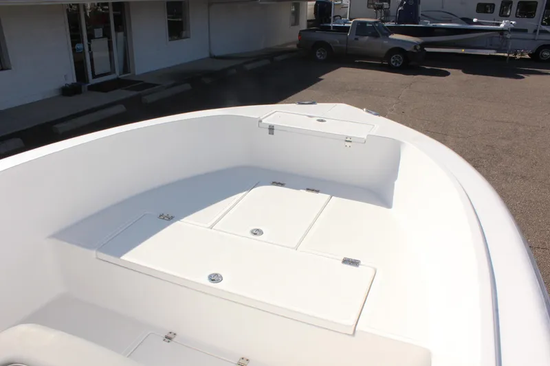 Slide: The Image of 2024 Clearwater 2000 CC boat deck, spacious and sleek design in a parking lot setting. - 11