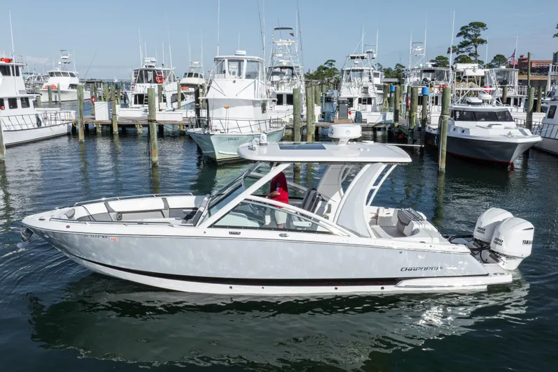 Slide: The Image of 2020 Chaparral 300 OSX boat docked at a marina with multiple yachts. - 10
