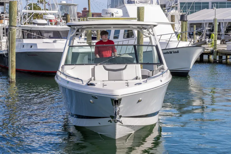 Slide: The Image of 2020 Chaparral 300 OSX boat docked in marina, front view. - 12