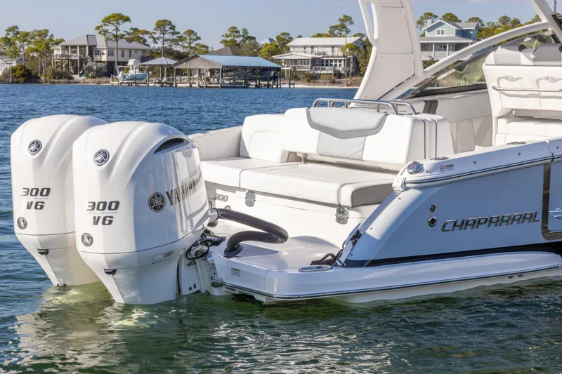 Slide: The Image of 2020 Chaparral 300 OSX boat with twin Yamaha 300 V6 engines on a serene waterfront. - 14