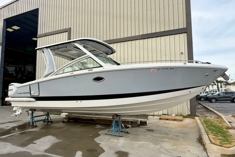 Slide: The Image of 2020 Chaparral 300 OSX boat displayed outside a large warehouse. - 16