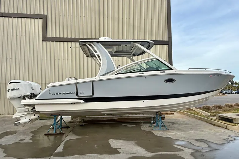 Slide: The Image of 2020 Chaparral 300 OSX boat with Yamaha engines, displayed on stands outside a warehouse. - 17