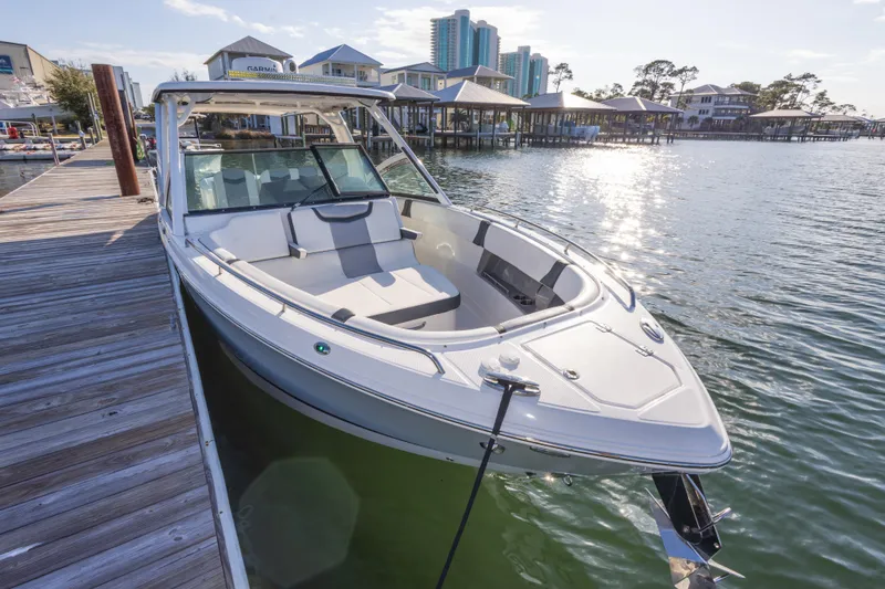 Slide: The Image of 2020 Chaparral 300 OSX boat docked by a wooden pier on a sunny day. - 20