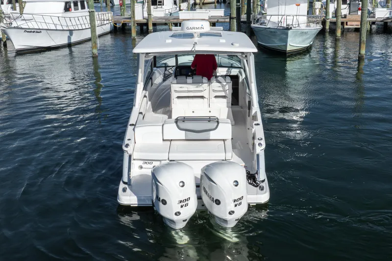 Slide: The Image of 2020 Chaparral 300 OSX boat with twin Yamaha engines docked in marina. - 24