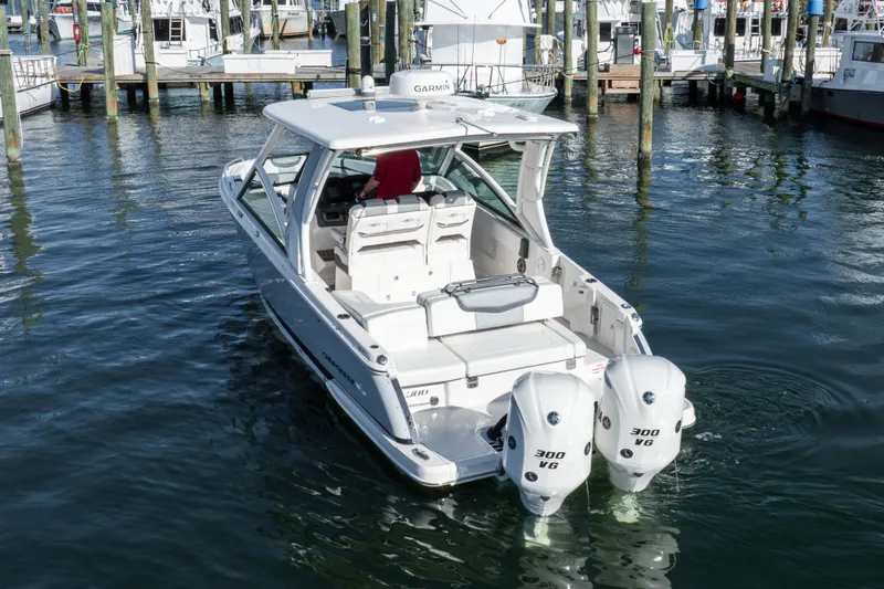 Slide: The Image of 2020 Chaparral 300 OSX boat with twin engines docked in marina. - 25