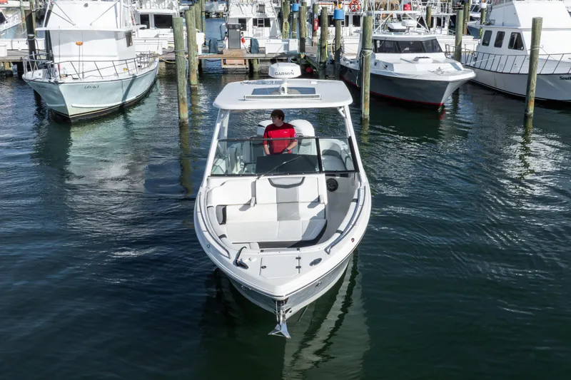 Slide: The Image of 2020 Chaparral 300 OSX boat docked in a marina, surrounded by other vessels. - 26