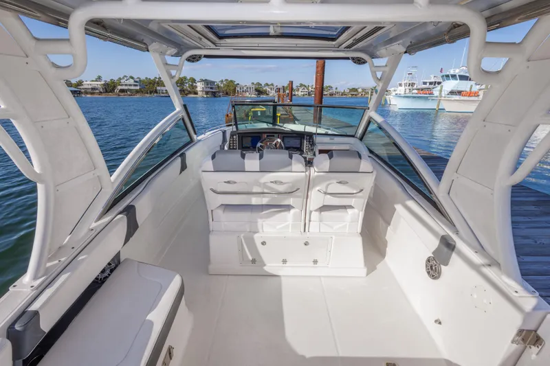 Slide: The Image of 2020 Chaparral 300 OSX boat interior with helm, seating, and waterfront view. - 30