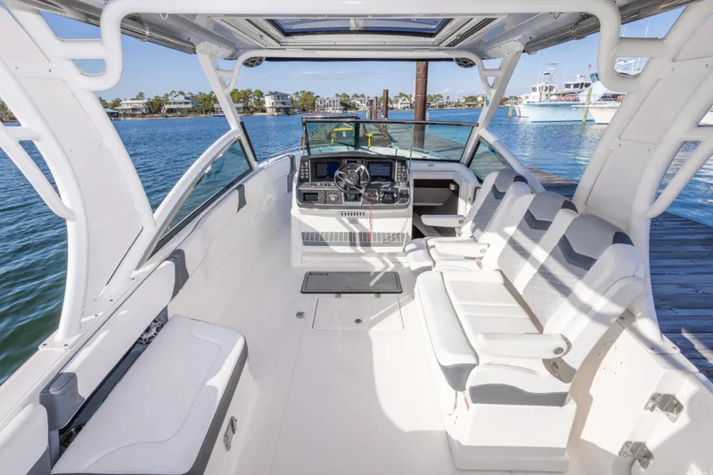 Slide: The Image of 2020 Chaparral 300 OSX boat interior with modern helm and seating, docked by the water. - 32